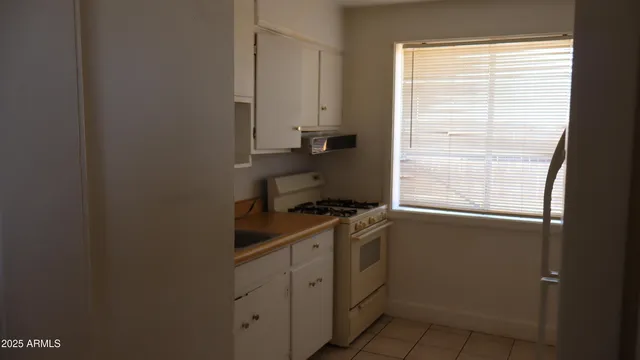 a kitchen with a stove cabinets and a window