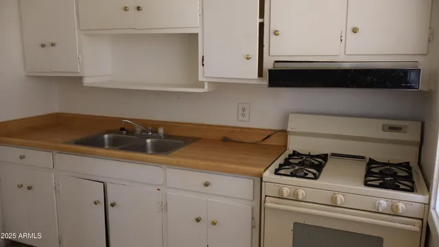 a kitchen with white cabinets and white appliances