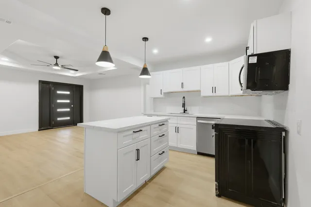 a large room with a couch and a view of kitchen