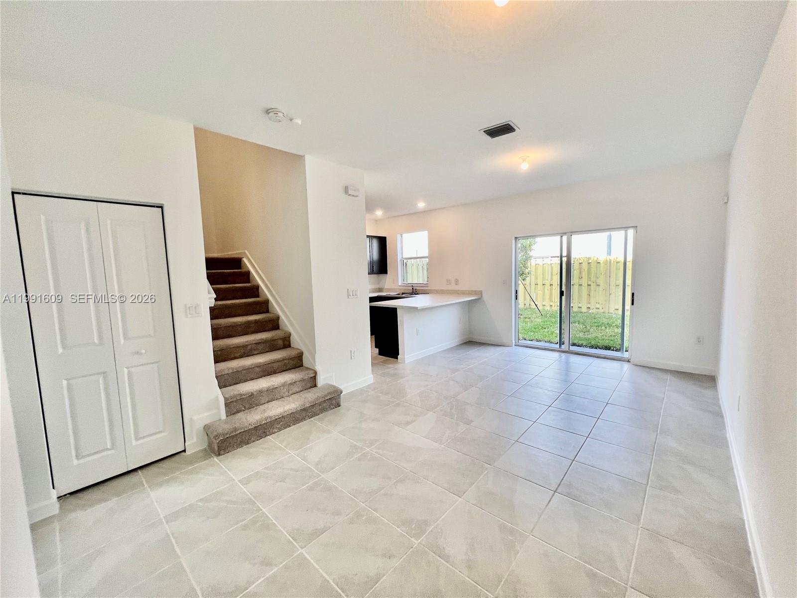 a view of a kitchen with wooden floor and stairs