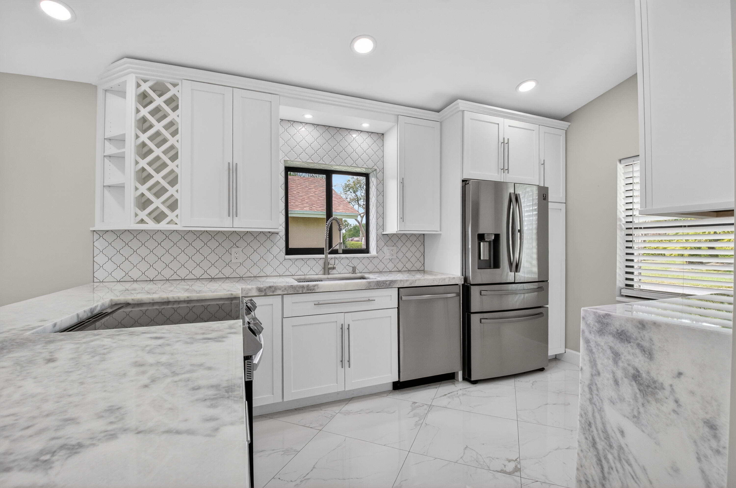 8216 Sweetbriar Way Boca Raton, FL 33496 - Photo 18 of 56 a kitchen with white cabinets and stainless steel appliances
