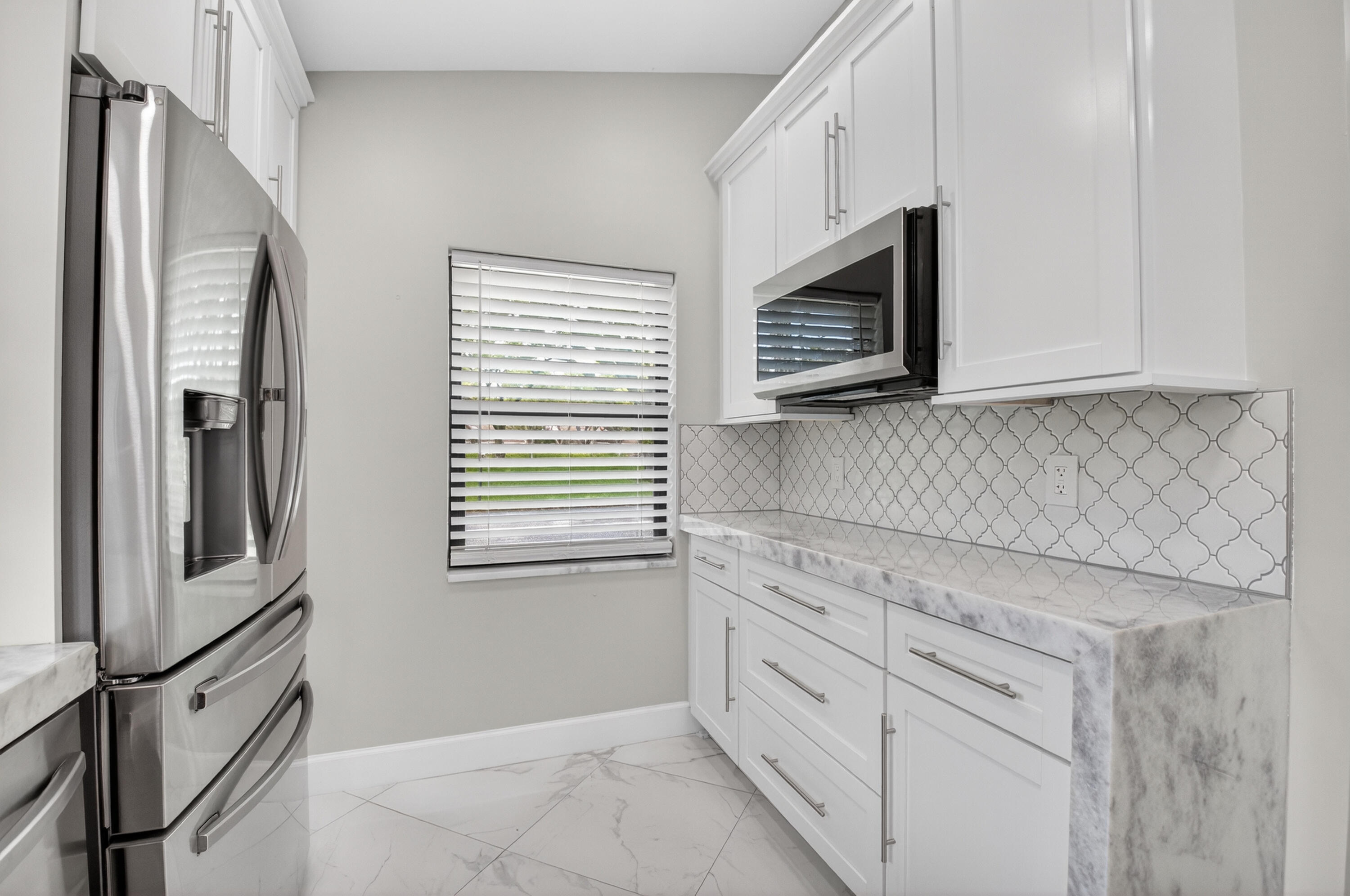 8216 Sweetbriar Way Boca Raton, FL 33496 - Photo 20 of 56 a kitchen with stainless steel appliances white cabinets and a microwave oven