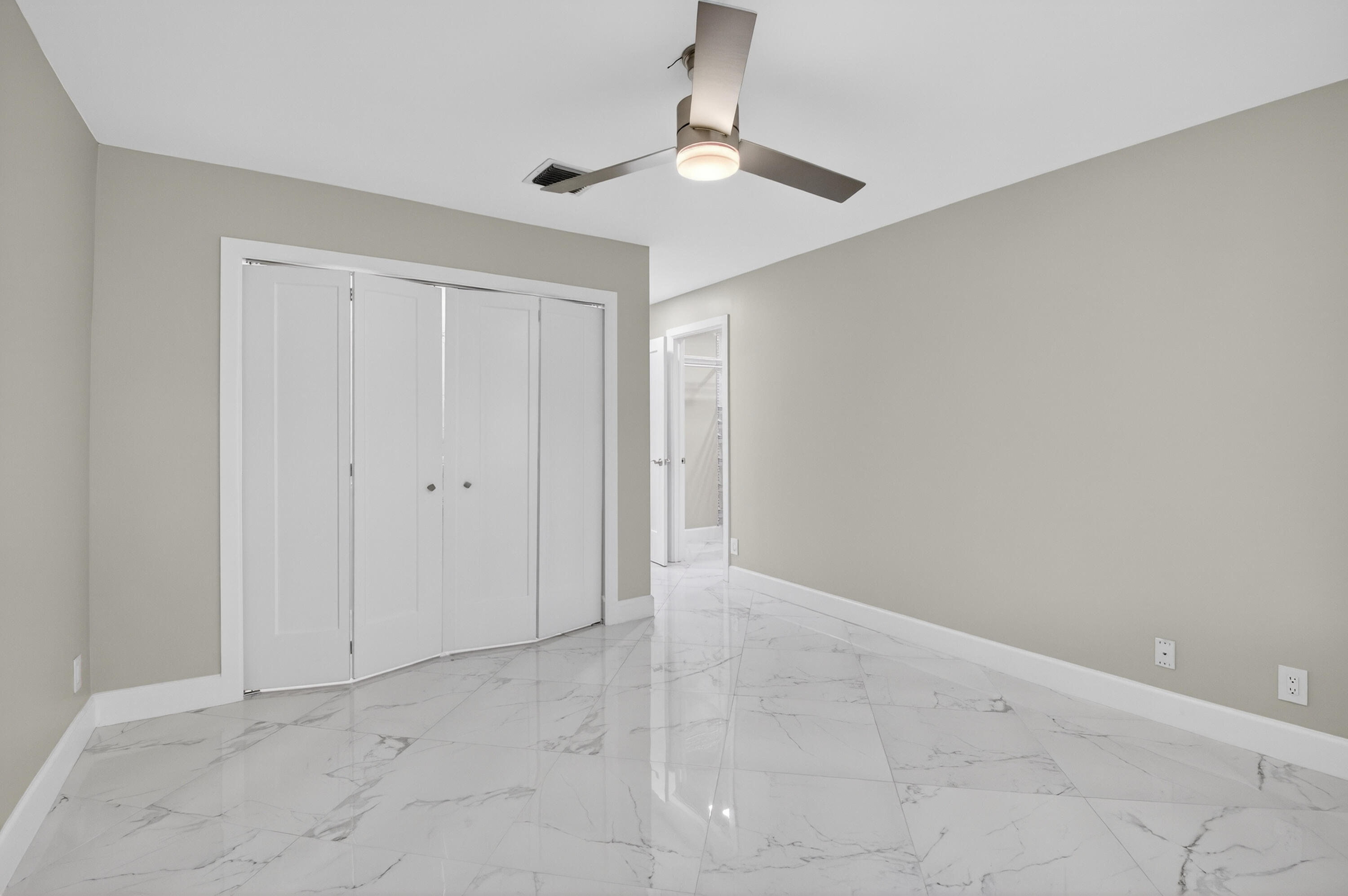 8216 Sweetbriar Way Boca Raton, FL 33496 - Photo 28 of 56 an empty room with a chandelier fan and closet area