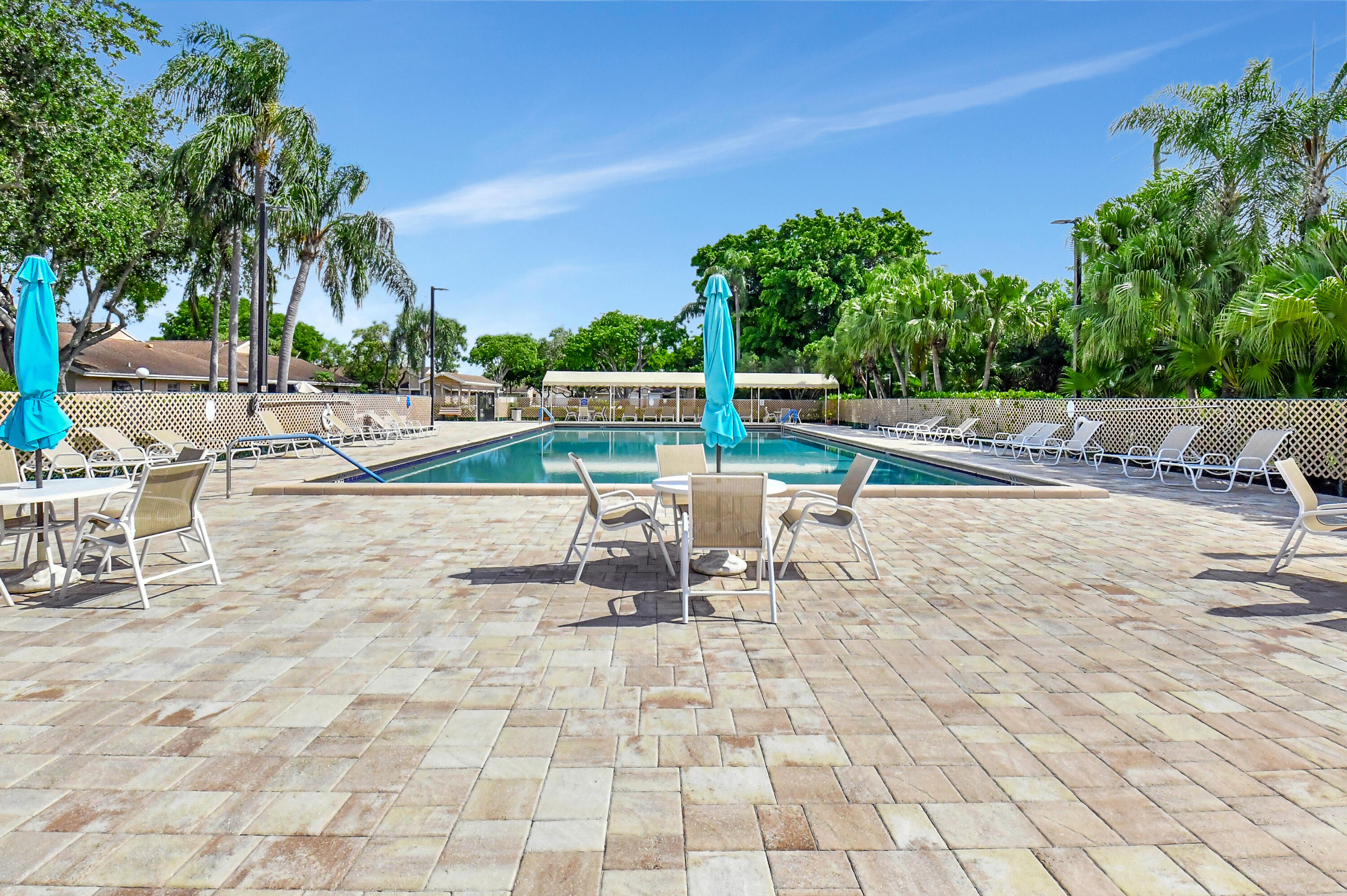 8216 Sweetbriar Way Boca Raton, FL 33496 - Photo 45 of 56 a view of a swimming pool with a lounge chair and a fire pit