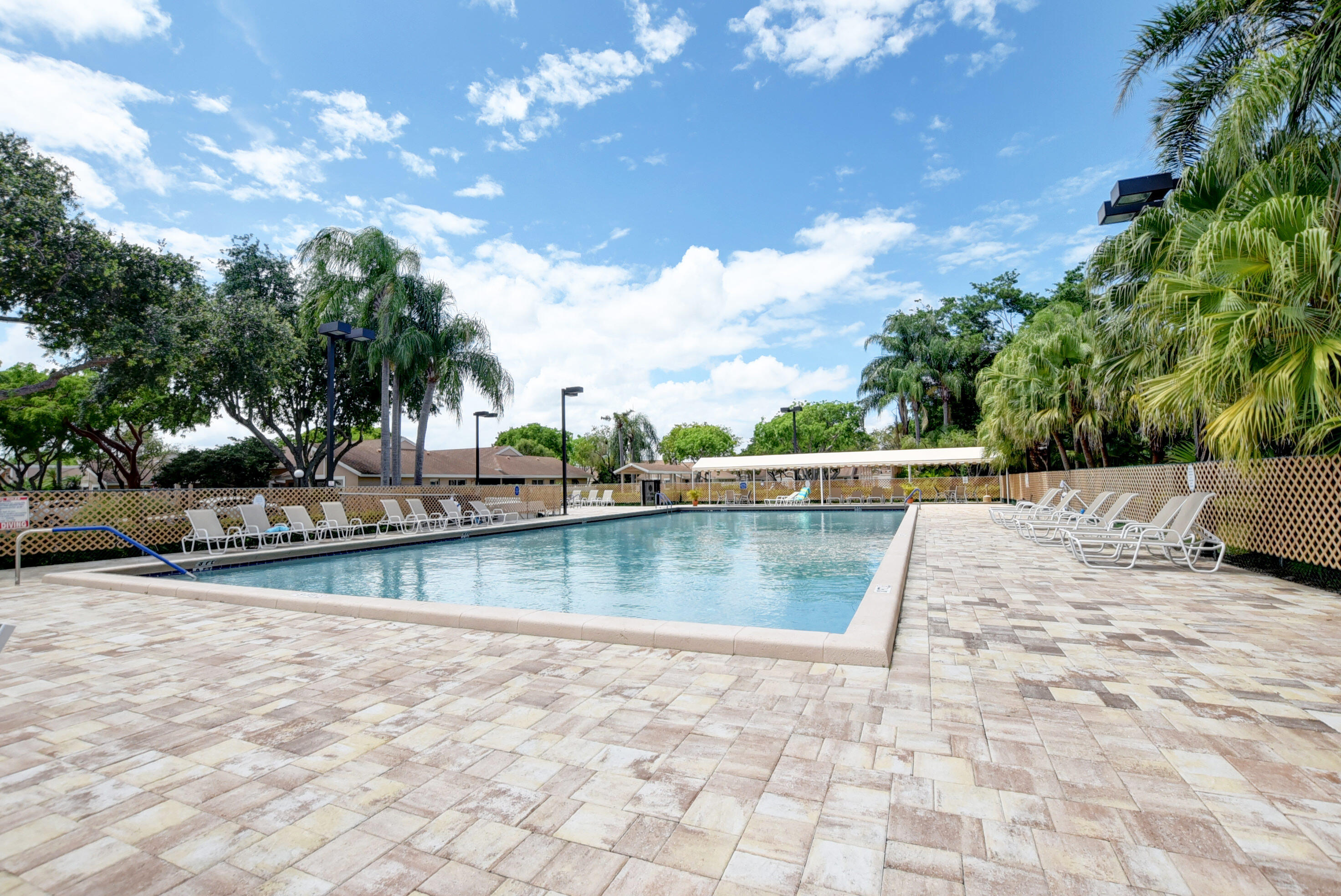 8216 Sweetbriar Way Boca Raton, FL 33496 - Photo 49 of 56 a view of a swimming pool with a chair and tables