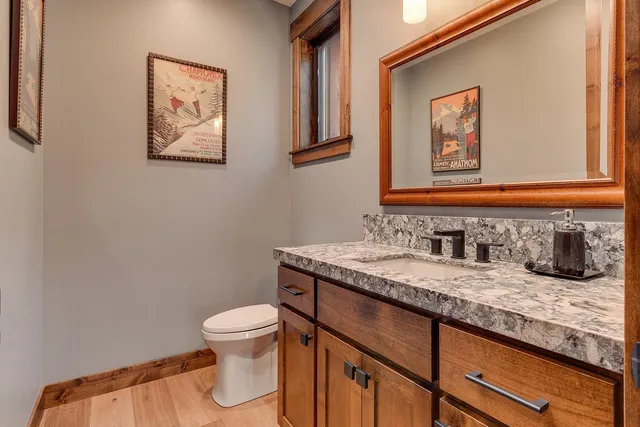 a bathroom with a granite countertop sink and a toilet