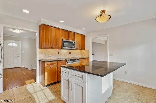 a kitchen with stainless steel appliances granite countertop a sink a stove counter space and cabinets