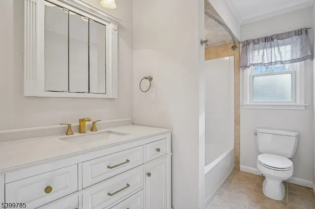 a bathroom with a toilet a sink a vanity and window