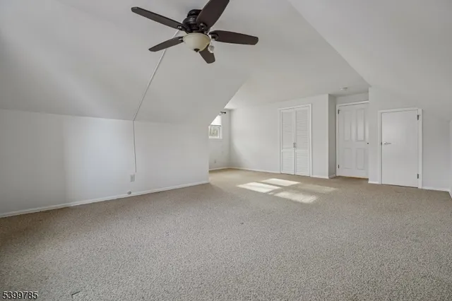 en empty room with ceiling fan and window