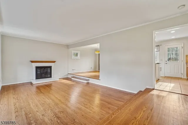an empty room with wooden floor and fireplace