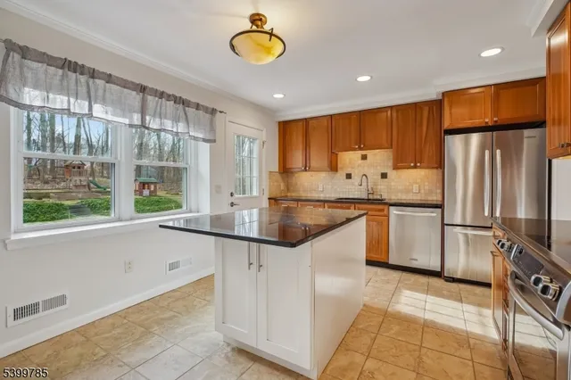 a kitchen with stainless steel appliances granite countertop a sink and a refrigerator
