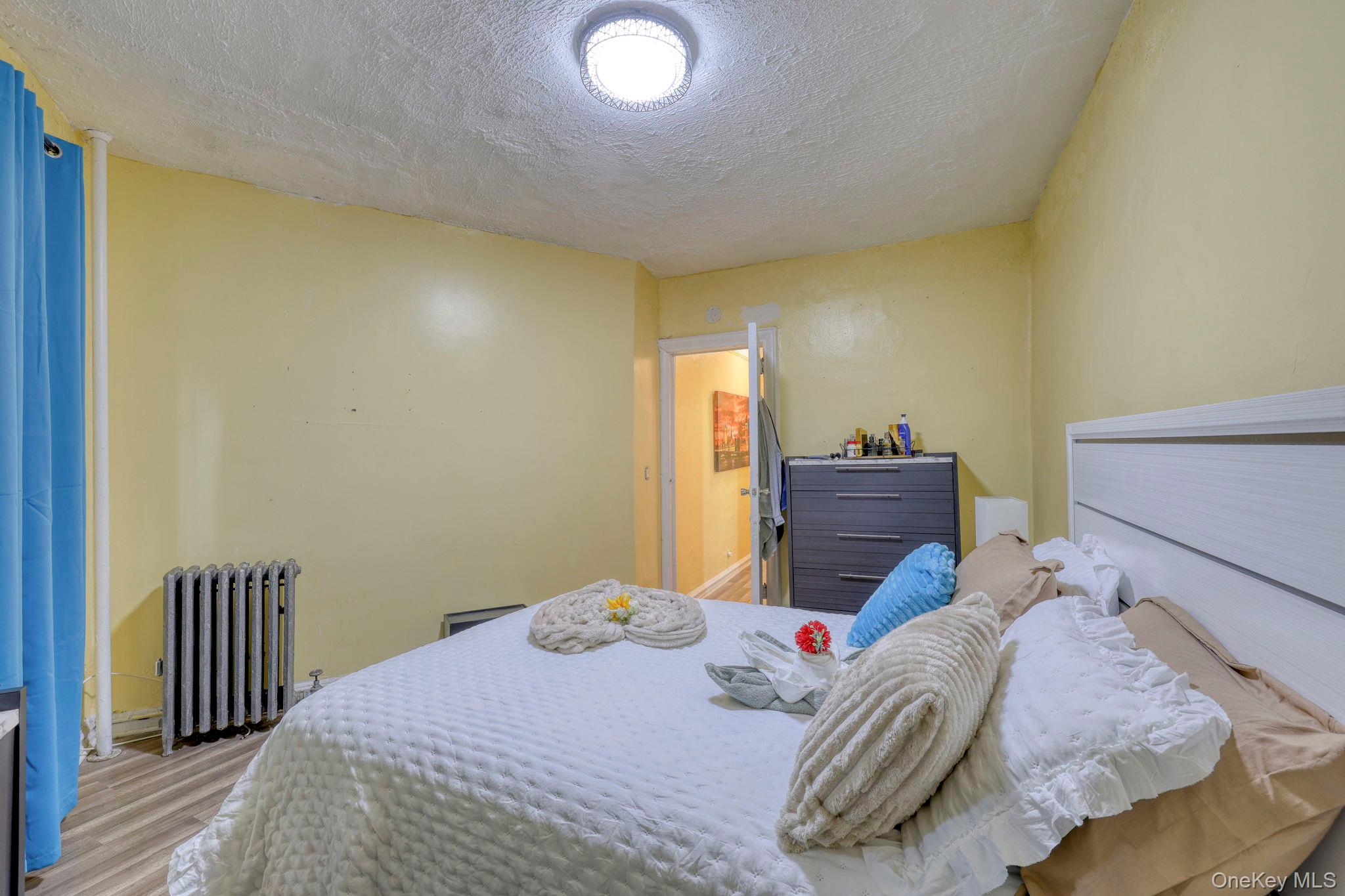 1372 Shakespeare Avenue, Unit 2H Bronx, NY 10452 - Photo 11 of 14 a bedroom with a bed and wooden floor