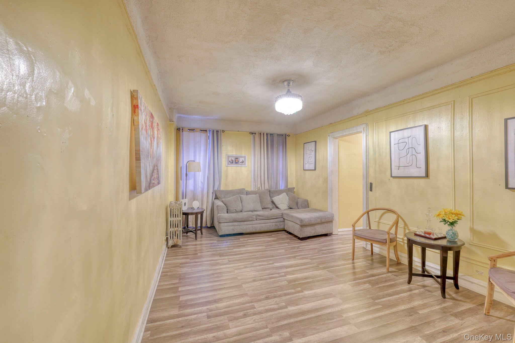 1372 Shakespeare Avenue, Unit 2H Bronx, NY 10452 - Photo 7 of 14 a living room with furniture and wooden floor