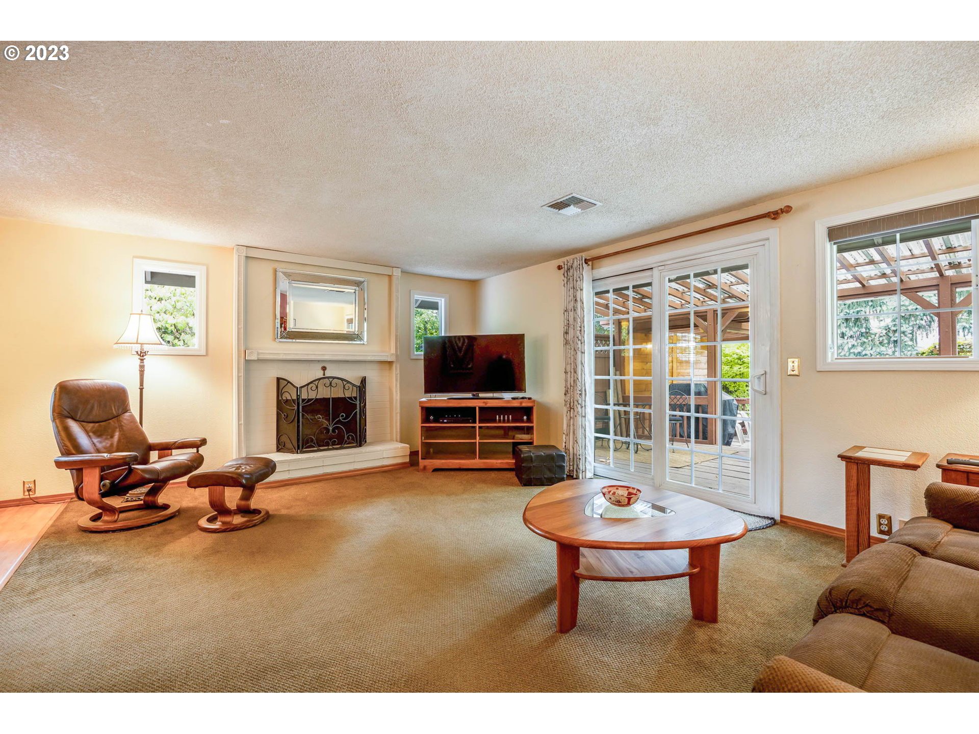 2565 Windsor Circle East Eugene, OR 97405 - Photo 16 of 38 a living room with furniture a fireplace and a flat screen tv