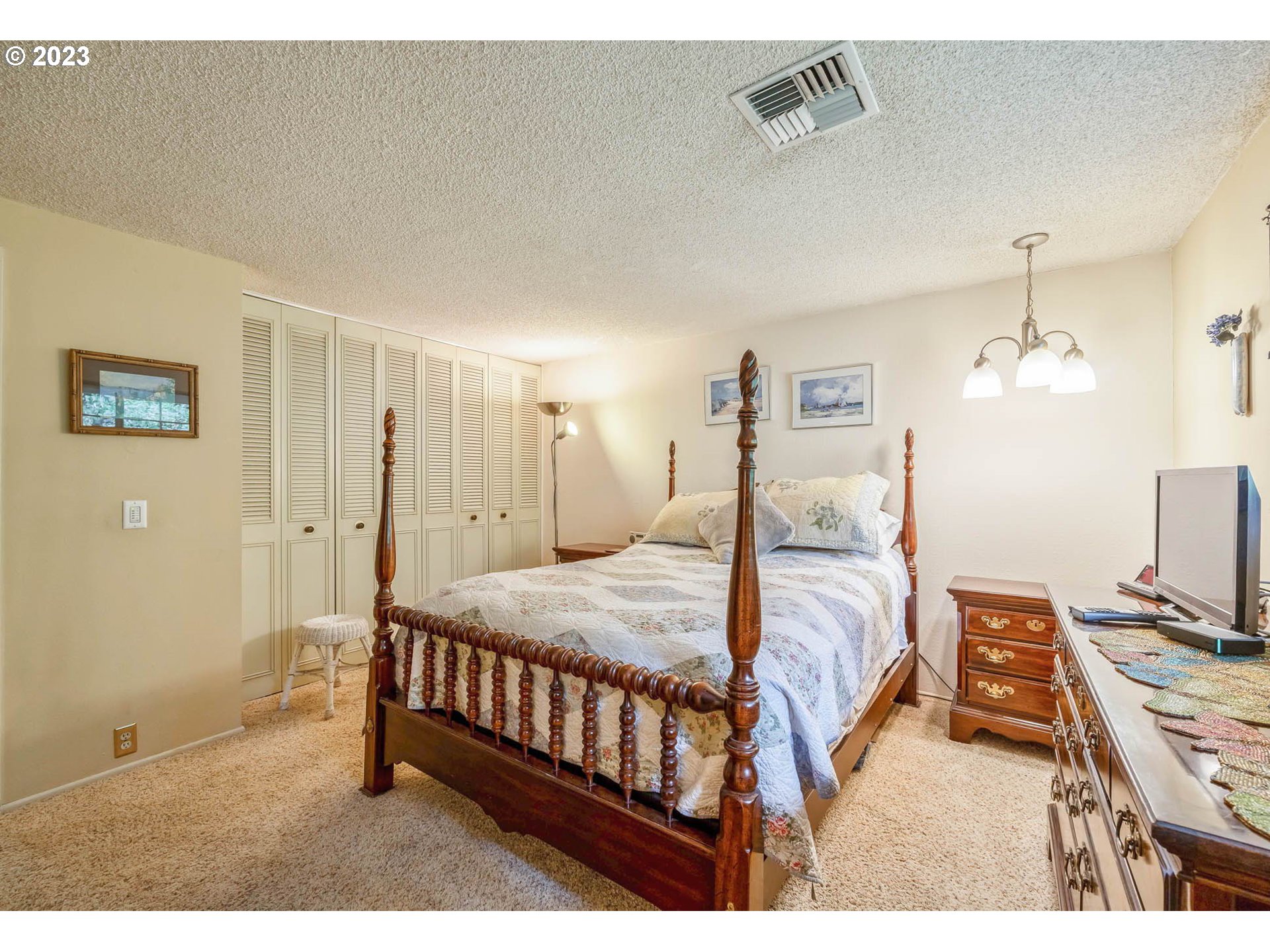 2565 Windsor Circle East Eugene, OR 97405 - Photo 22 of 38 a bedroom with a bed chandelier and a window
