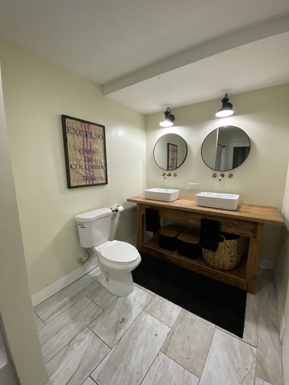 656 Grove Street, Unit 1 Worcester, MA 01605 - Photo 12 of 18 a bathroom with a toilet a sink and cabinets