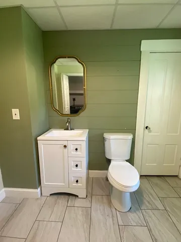 a bathroom with a toilet sink and mirror