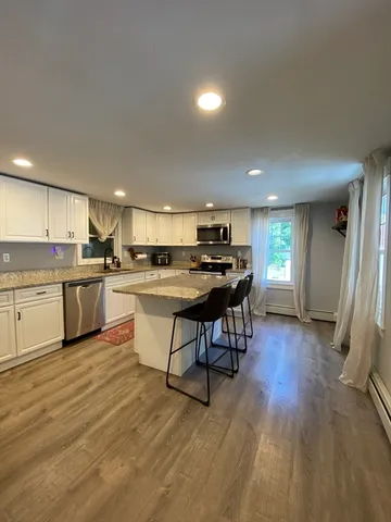 a kitchen with a table chairs refrigerator and cabinets