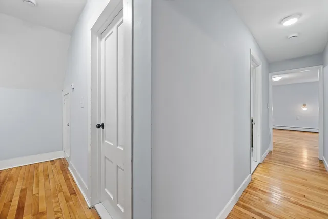a view of a hallway with wooden floor and staircase