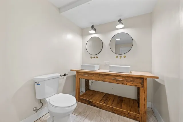 a bathroom with a toilet sink vanity and mirror