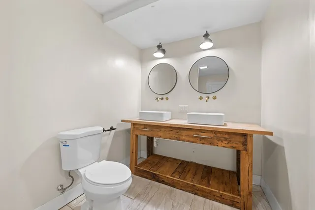 a bathroom with a toilet sink vanity and mirror