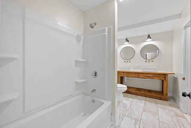a bathroom with a sink a mirror and bathtub
