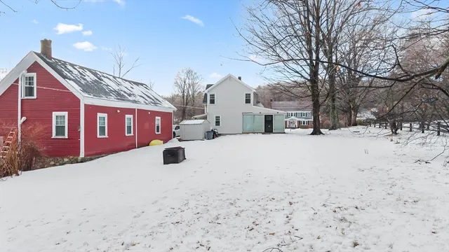 a front view of a building with large trees