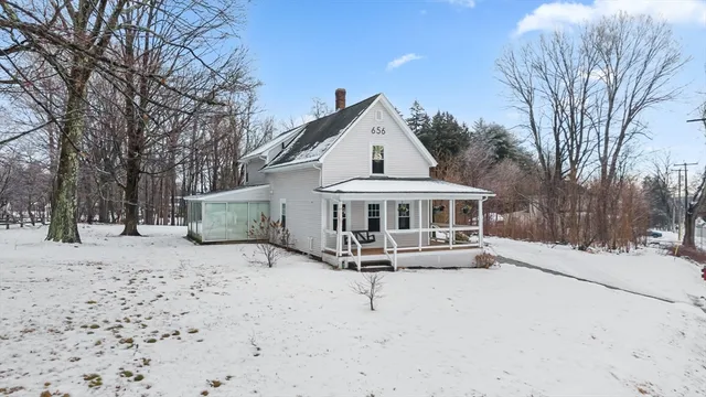 a view of a house with a yard covered in snow