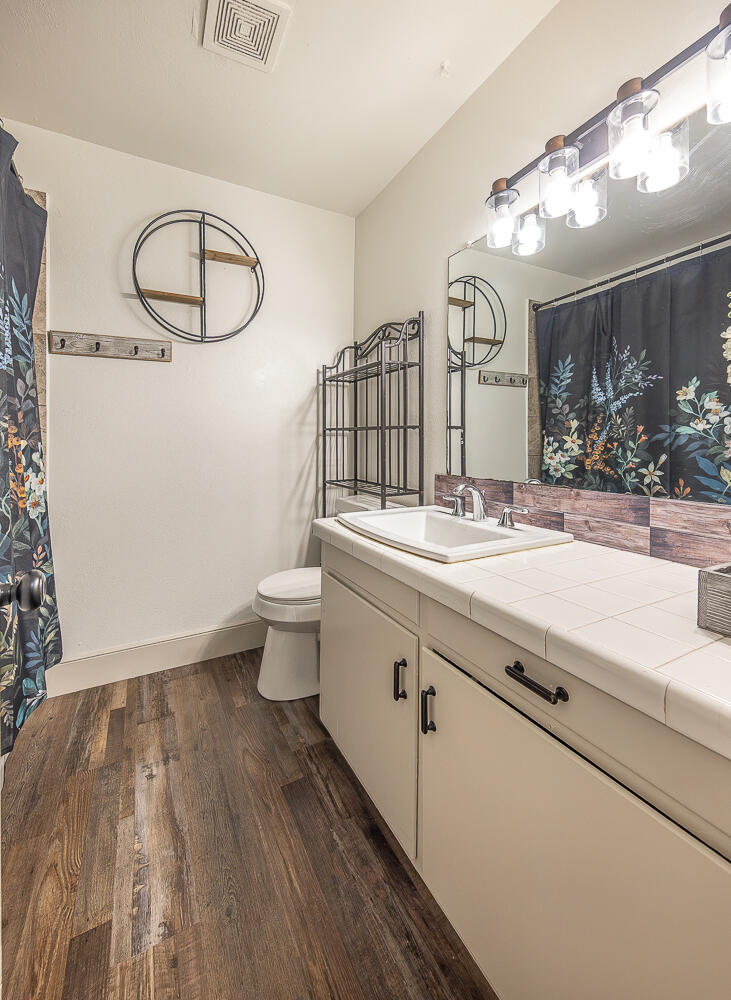 1710 43rd Street Lubbock, TX 79412 - Photo 13 of 20 a bathroom with a sink mirror and toilet