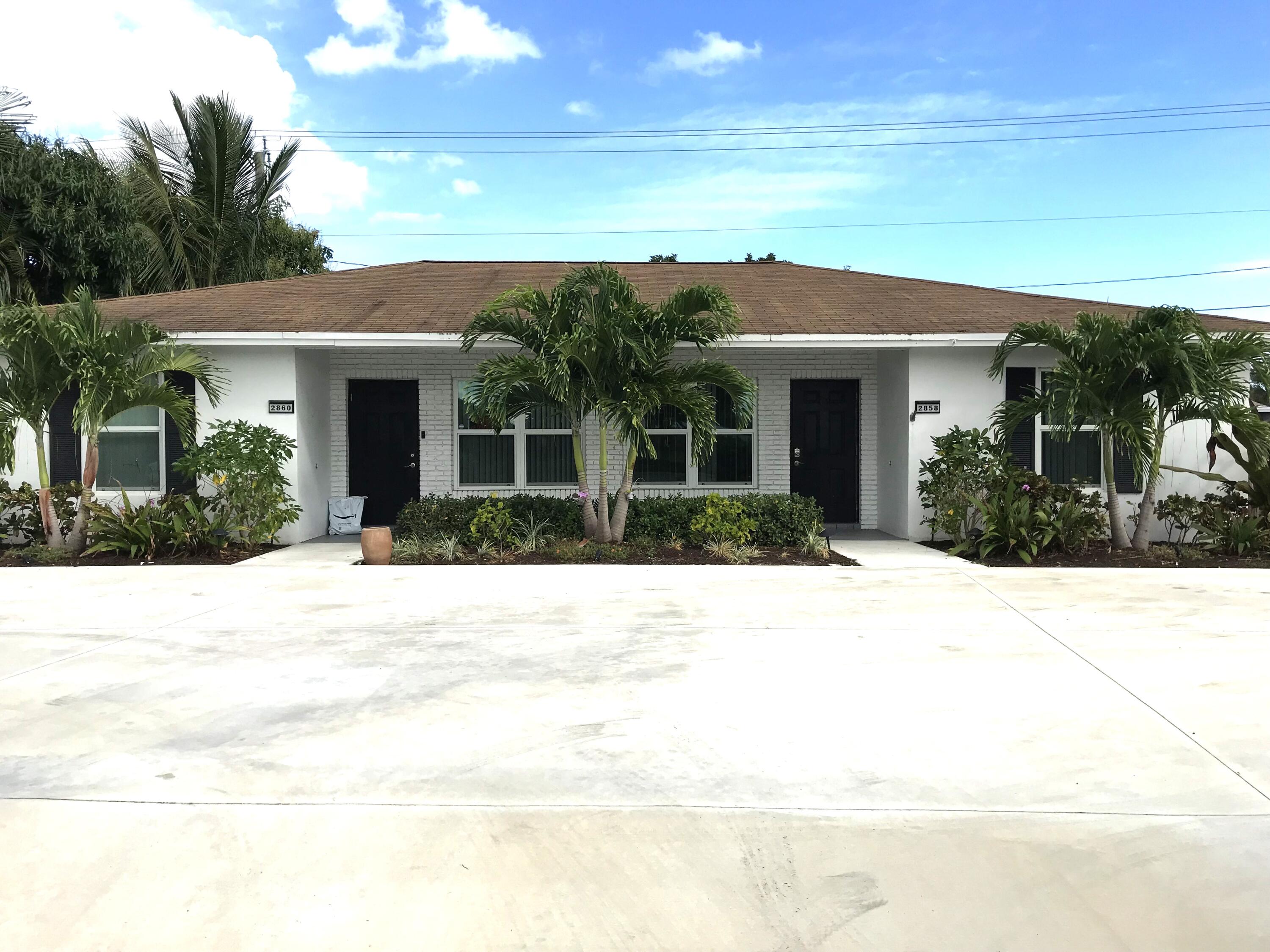 a front view of a house with a yard and potted plants