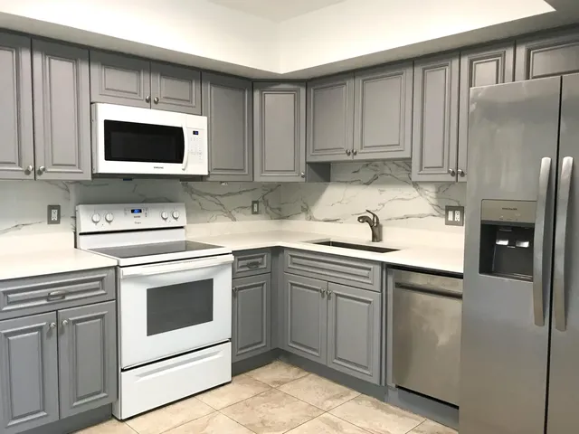 a kitchen with stainless steel appliances granite countertop a sink a stove a microwave and cabinets