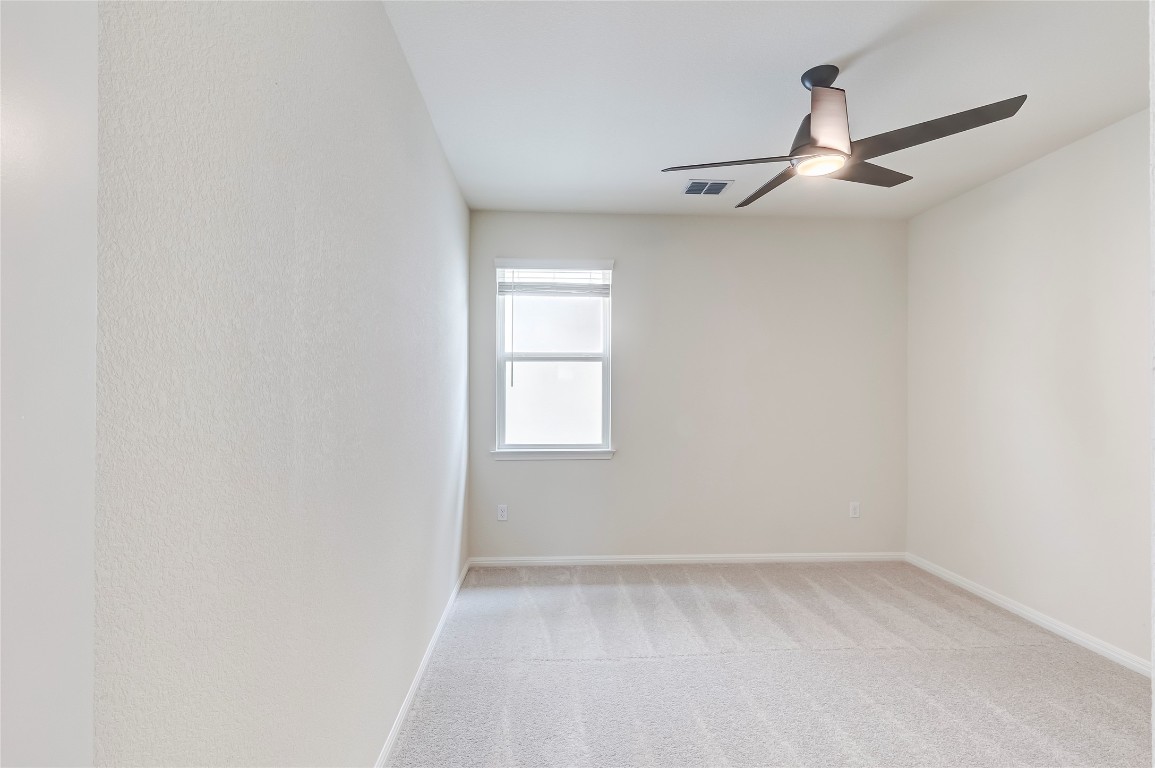 2008 Kit Circle Austin, TX 78758 - Photo 27 of 37 Empty room with light colored carpet and a ceiling fan