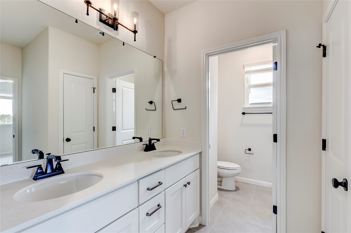 2008 Kit Circle Austin, TX 78758 - Photo 29 of 37 Full bathroom with double vanity and light tile patterned flooring