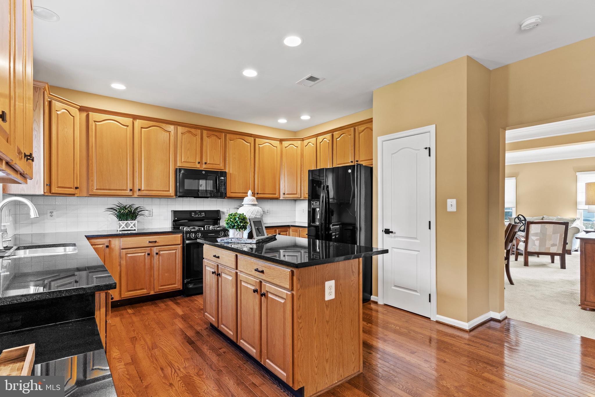 42714 Freedom Street Chantilly, VA 20152 - Photo 12 of 47 a kitchen with granite countertop a refrigerator stove top oven and sink