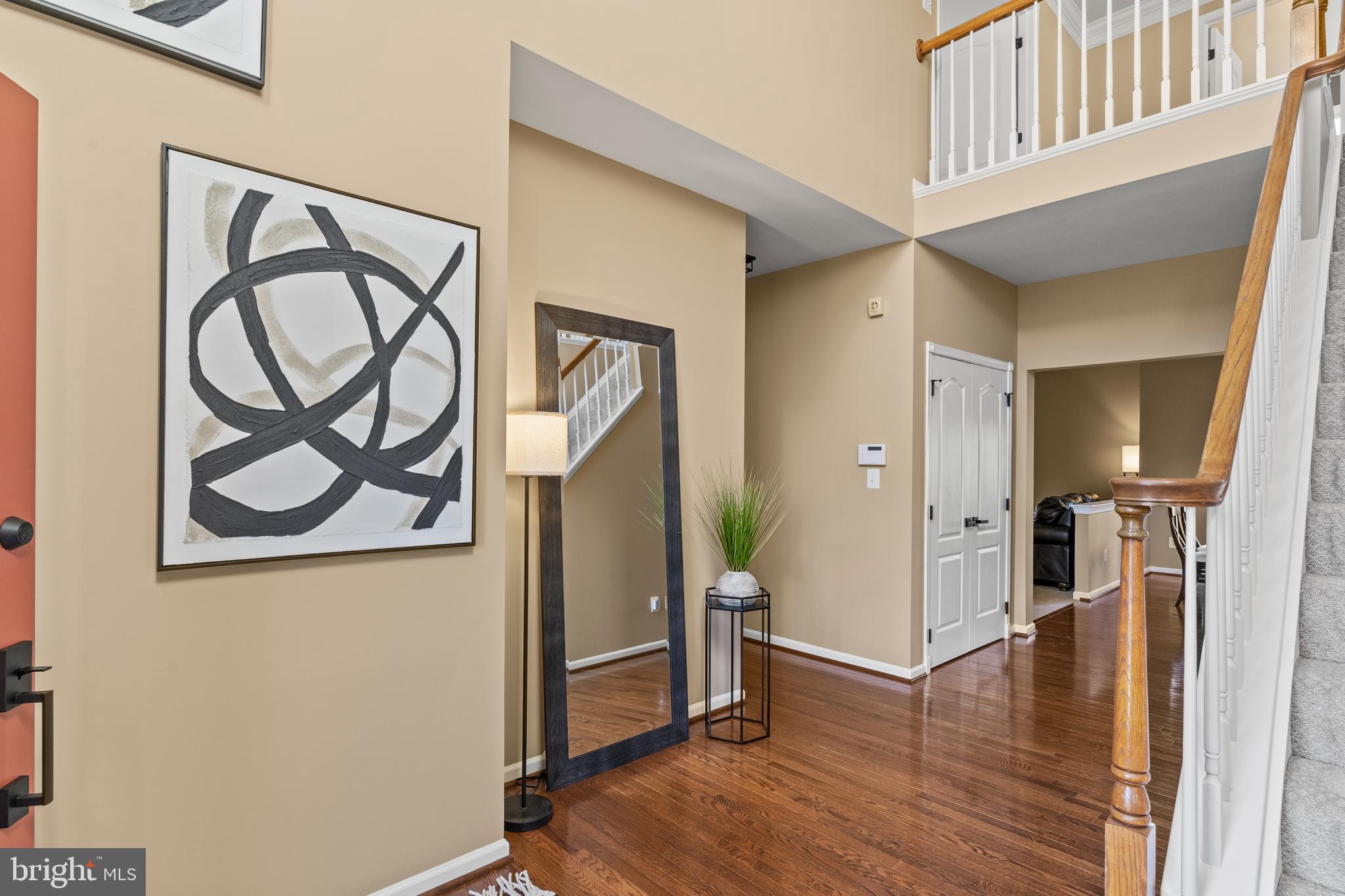 42714 Freedom Street Chantilly, VA 20152 - Photo 4 of 47 a view of a hallway with wooden floor and a potted plant on a dresser