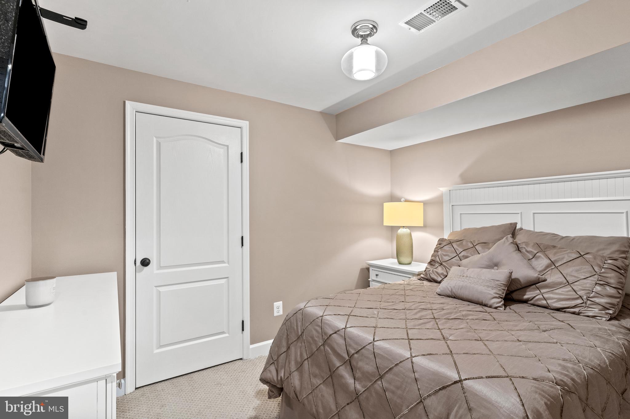 42714 Freedom Street Chantilly, VA 20152 - Photo 41 of 47 a bedroom with a bed and a flat tv screen on dresser