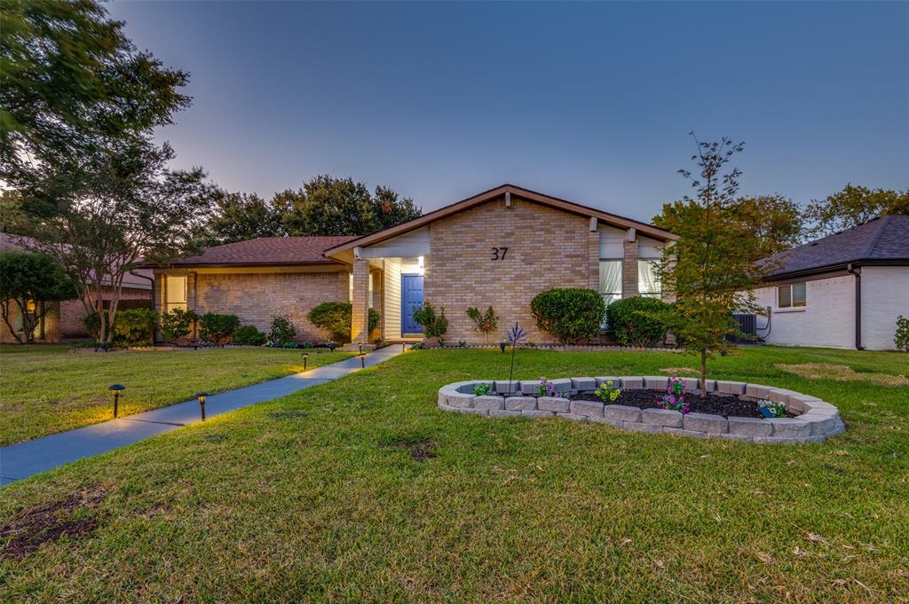 View of front facade featuring a front yard and brick siding