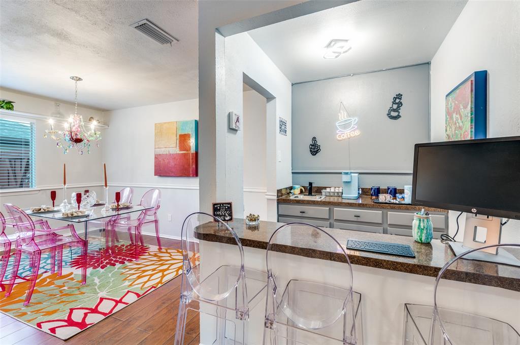 37 Merrie Circle Richardson, TX 75081 - Photo 13 of 28 Kitchen featuring dark wood-type flooring, a chandelier, decorative light fixtures, dark stone countertops, and a textured ceiling