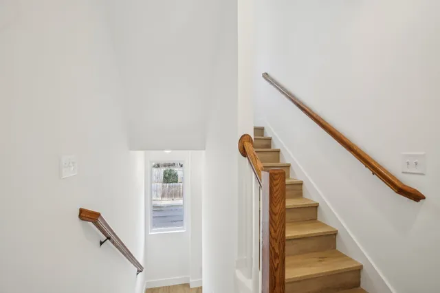 an empty room with wooden floor and ceiling fan
