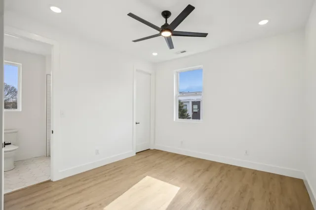 a view of a hallway with wooden floor and closet