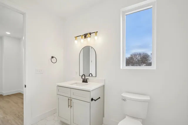a bathroom with a sink a toilet and a mirror