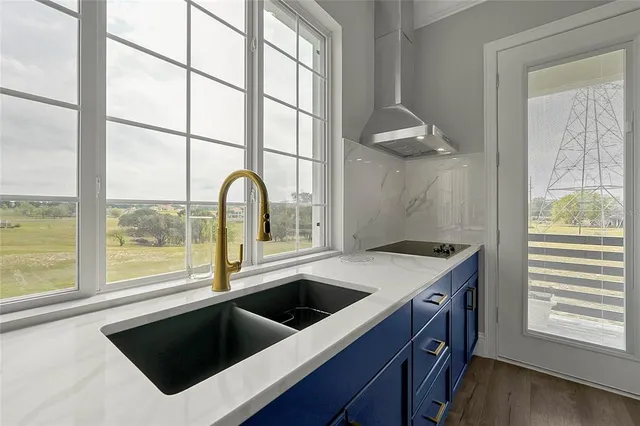 a large kitchen with stainless steel appliances granite countertop a lot of counter space and wooden floors