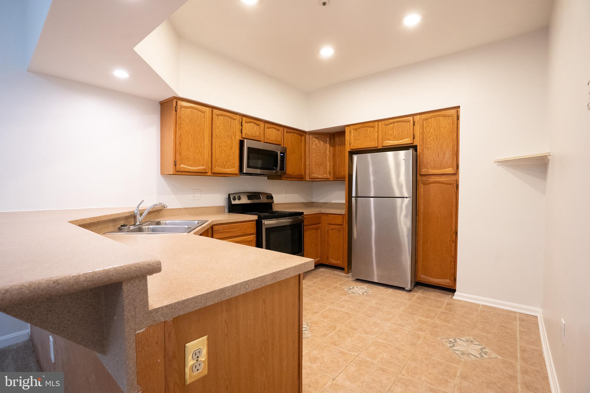 2707 Summerview Way, Unit 101 Annapolis, MD 21401 - Photo 3 of 24 a kitchen with a refrigerator a stove top oven a sink and dishwasher