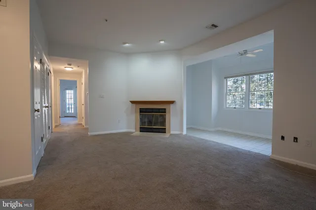 an empty room with windows and fireplace