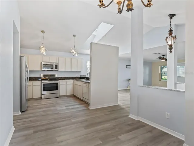 a kitchen with granite countertop a refrigerator oven a sink and dishwasher