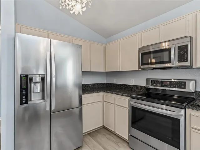 a kitchen with stainless steel appliances granite countertop a refrigerator stove and microwave