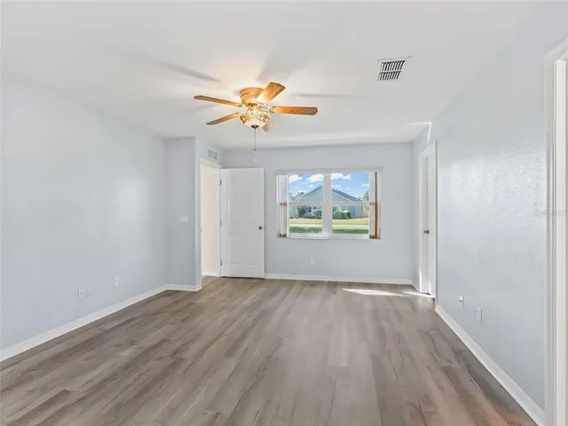 an empty room with wooden floor and window