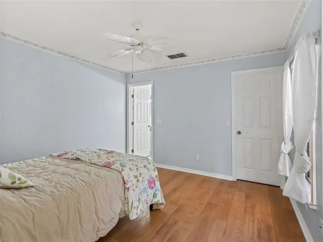 a bedroom with a bed and a chandelier fan