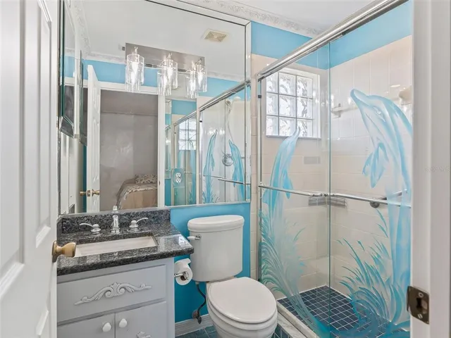 a bathroom with a granite countertop sink toilet and shower