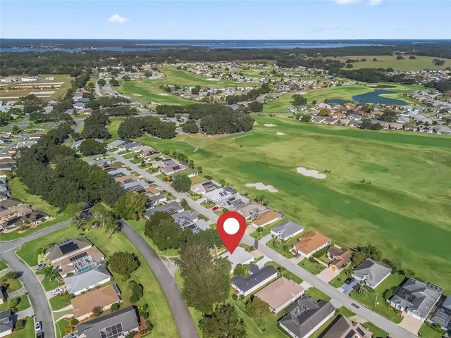 an aerial view of residential houses with outdoor space and ocean view